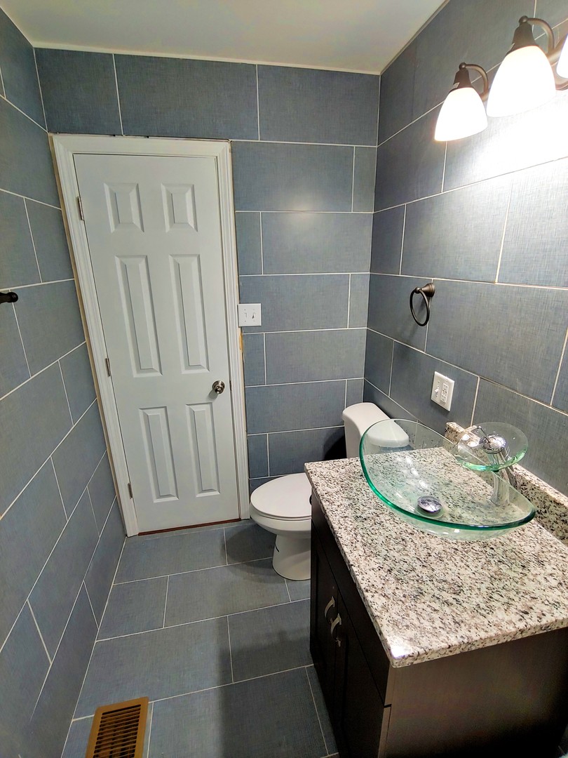 120 Edison Road Joliet, IL 60433 - Photo 13 of 21 a bathroom with a granite countertop sink a toilet and mirror