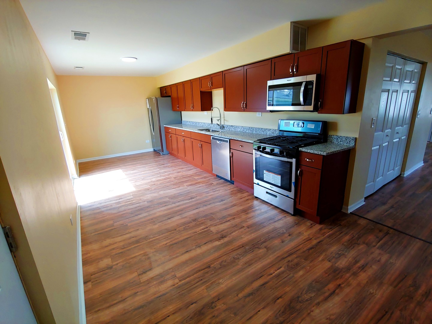 120 Edison Road Joliet, IL 60433 - Photo 6 of 21 a kitchen with stainless steel appliances wooden floors and wooden cabinets