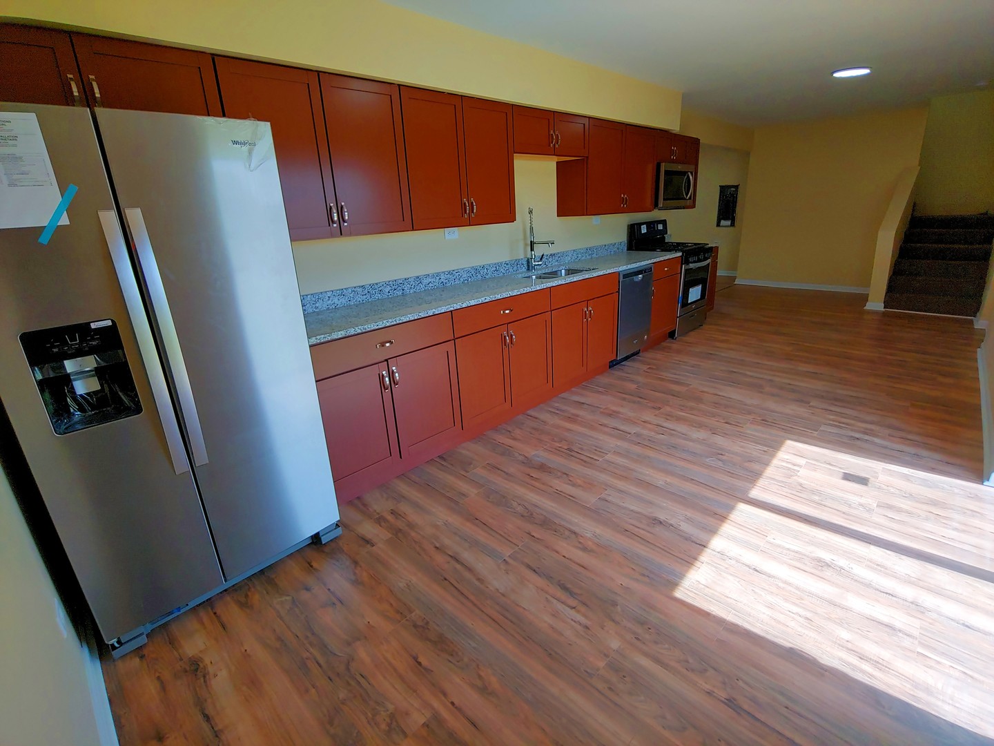 120 Edison Road Joliet, IL 60433 - Photo 7 of 21 a kitchen with stainless steel appliances a refrigerator a sink a stove top oven a wooden floor and cabinets