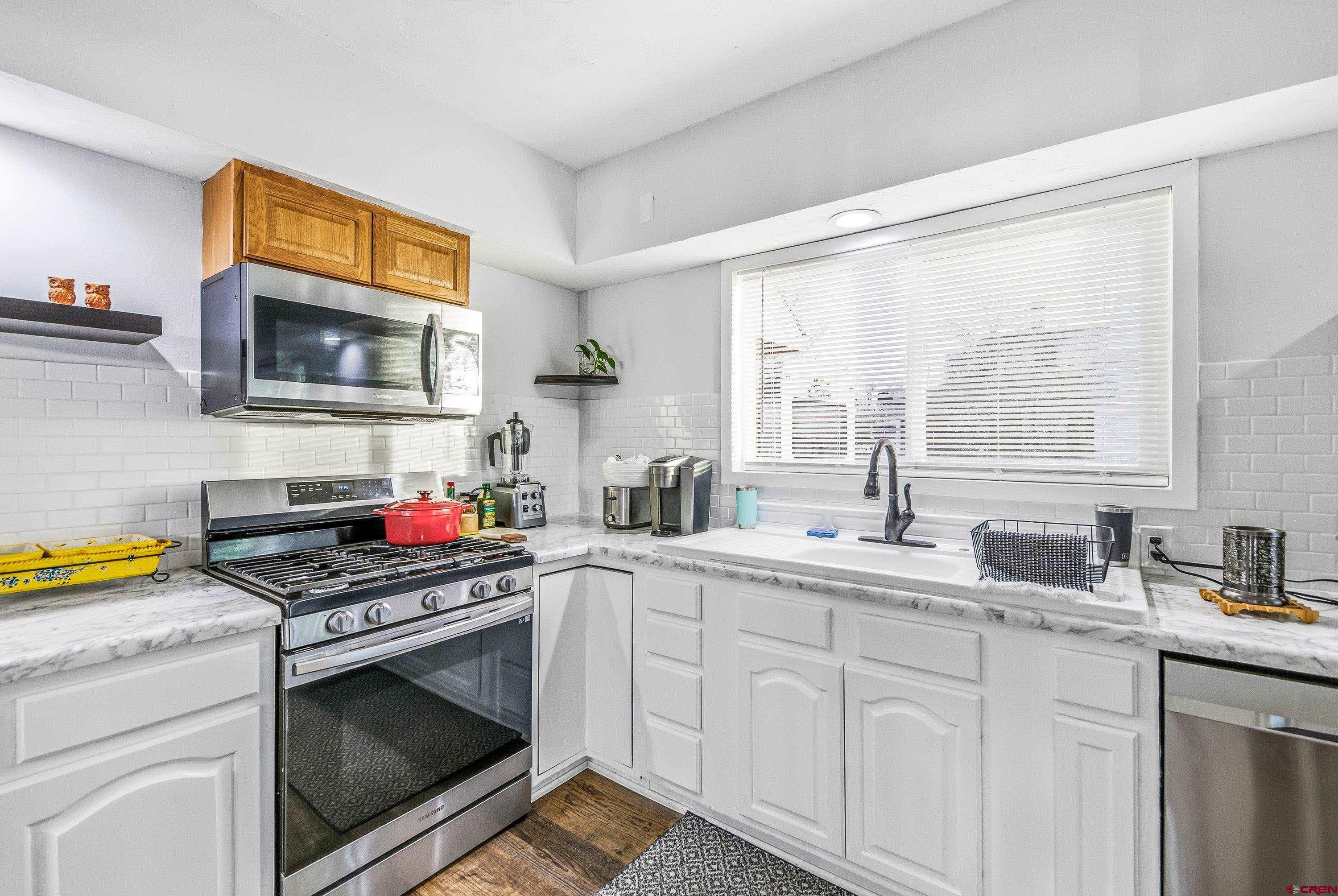 249 Park Street Delta, CO 81416 - Photo 14 of 22 a kitchen with stainless steel appliances a stove sink and cabinets