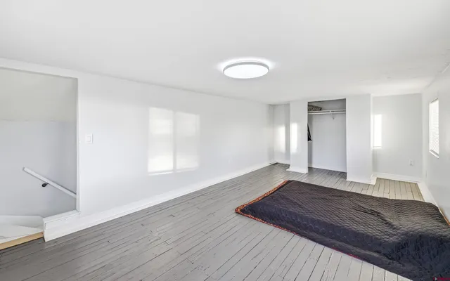 a view of a room with wooden floor and window