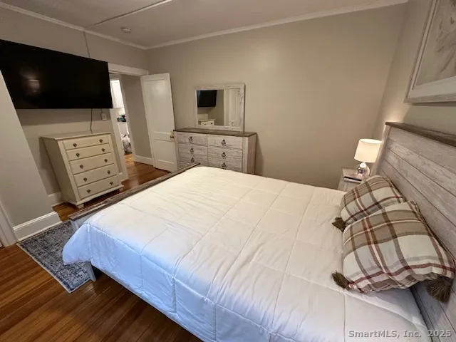 a bedroom with a bed a flat screen tv and a couch