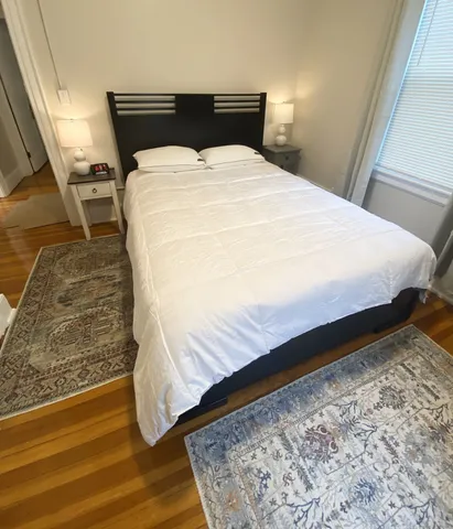a bed sitting in a bedroom with wooden floor