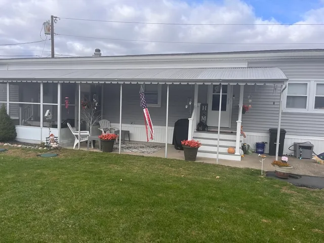 a view of a house with backyard and sitting area