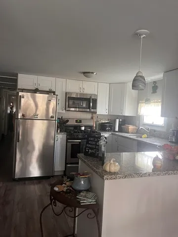 a kitchen with granite countertop a refrigerator stove and sink