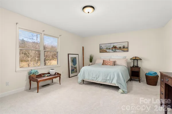 a spacious bedroom with a bed and a window