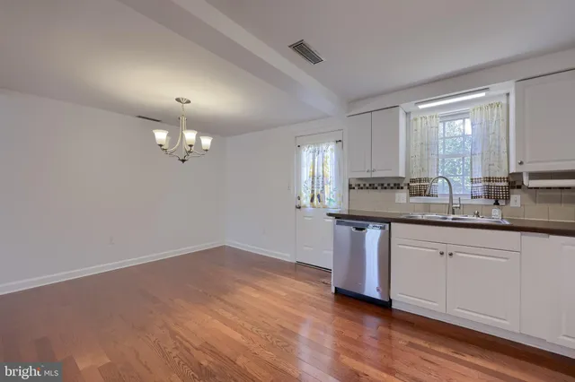 a kitchen with stainless steel appliances granite countertop a sink cabinets a stove and a refrigerator