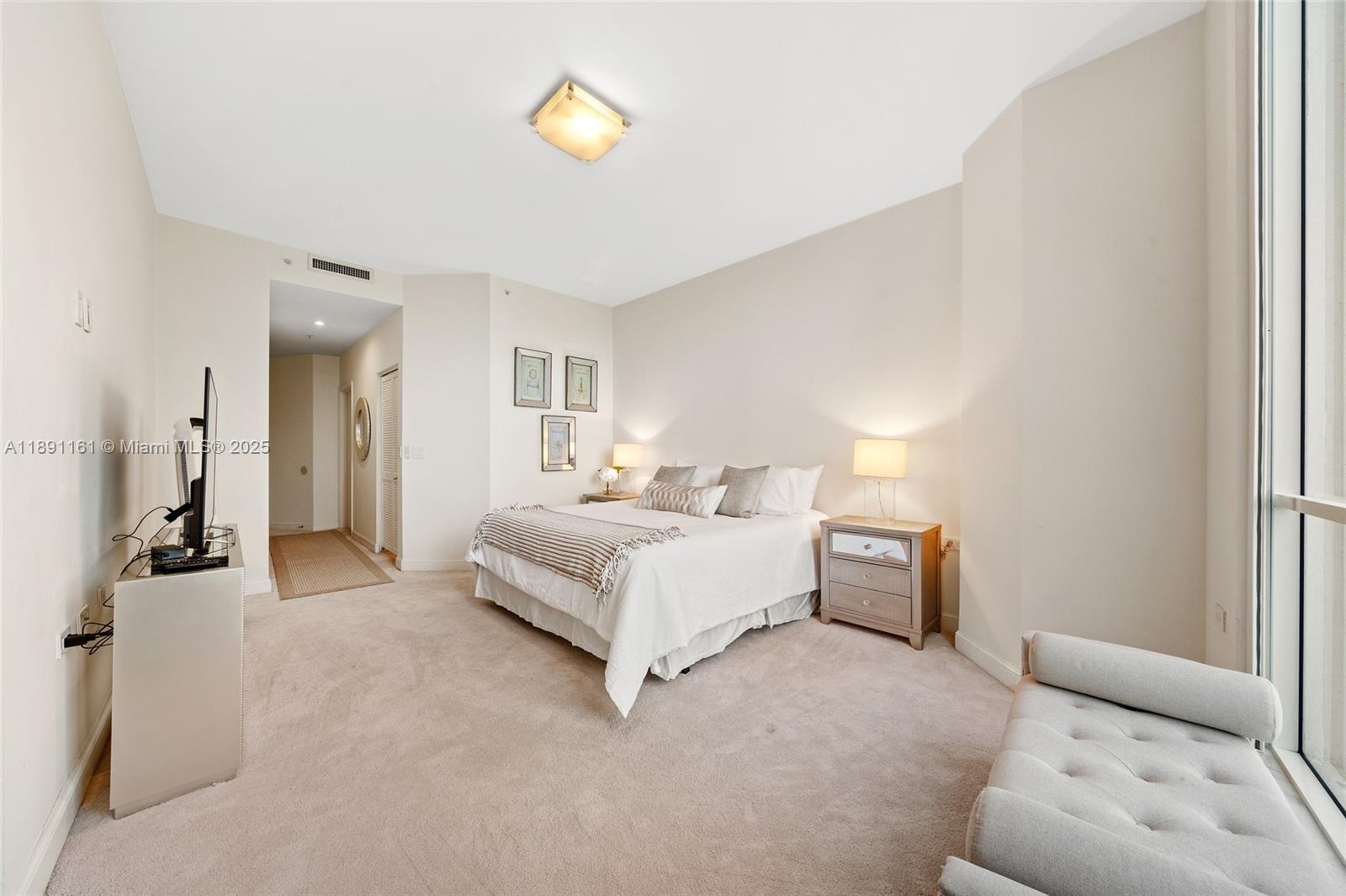 848 Brickell Key Drive, Unit 201 Miami, FL 33131 - Photo 12 of 31 a bedroom with a bed and a couch