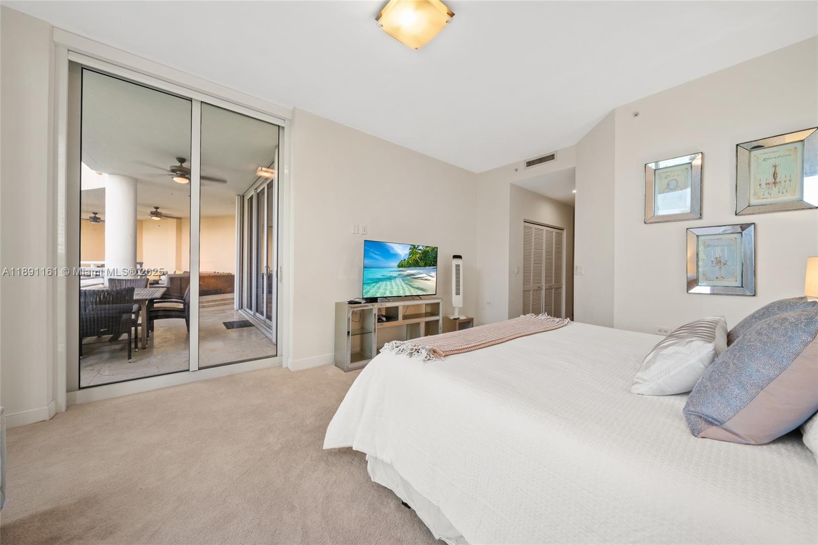 848 Brickell Key Drive, Unit 201 Miami, FL 33131 - Photo 13 of 31 a bedroom with a bed and a chandelier