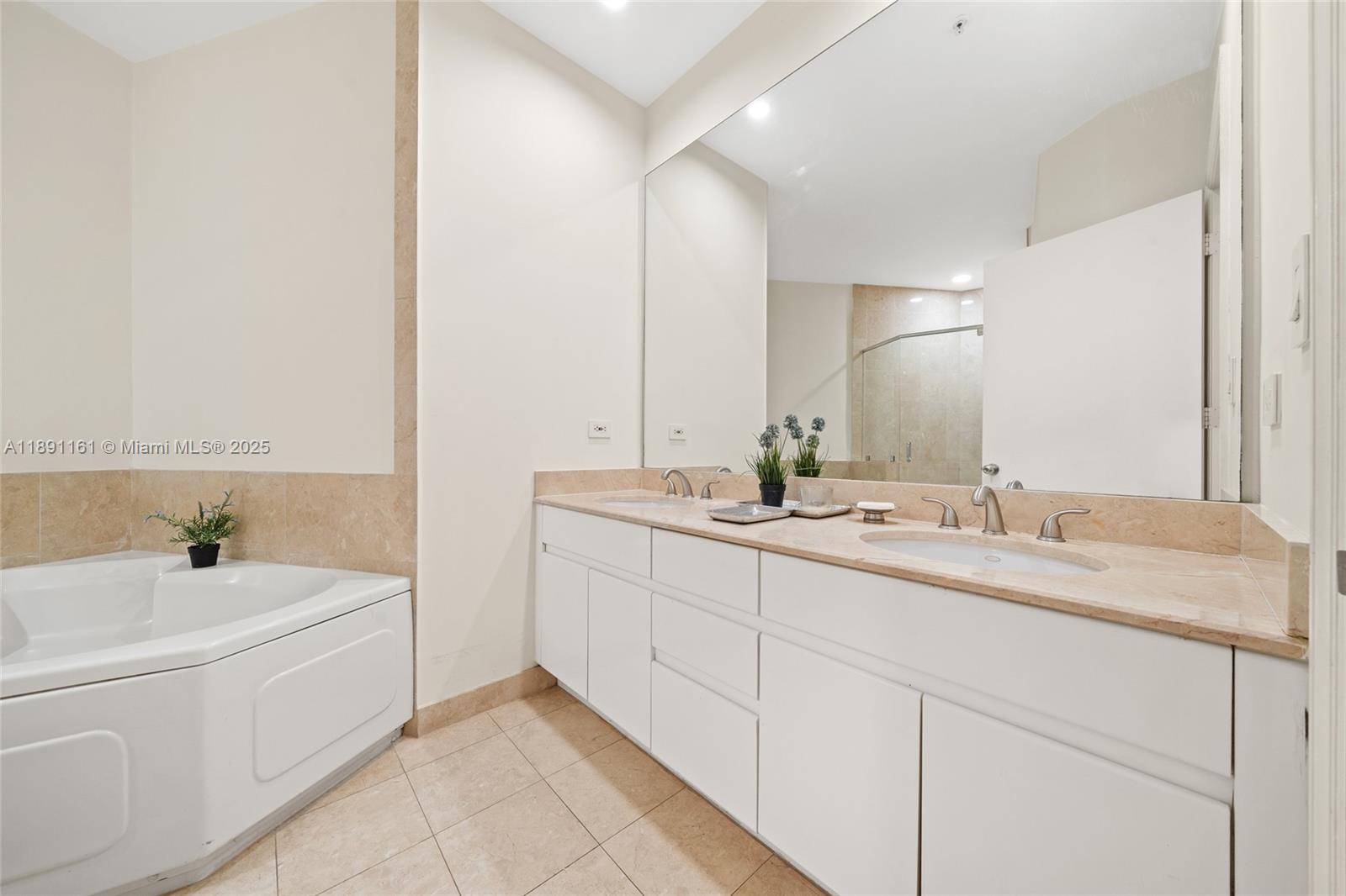 848 Brickell Key Drive, Unit 201 Miami, FL 33131 - Photo 14 of 31 a bathroom with a tub sink and mirror