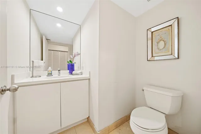 a bathroom with a toilet sink vanity and mirror