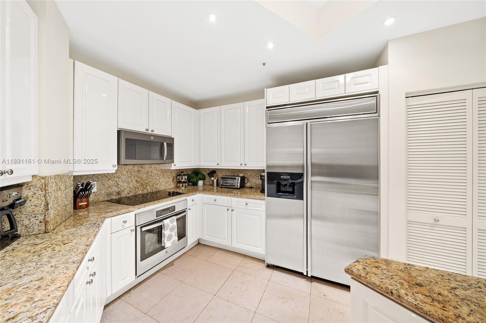 848 Brickell Key Drive, Unit 201 Miami, FL 33131 - Photo 10 of 31 a kitchen with white cabinets and white appliances