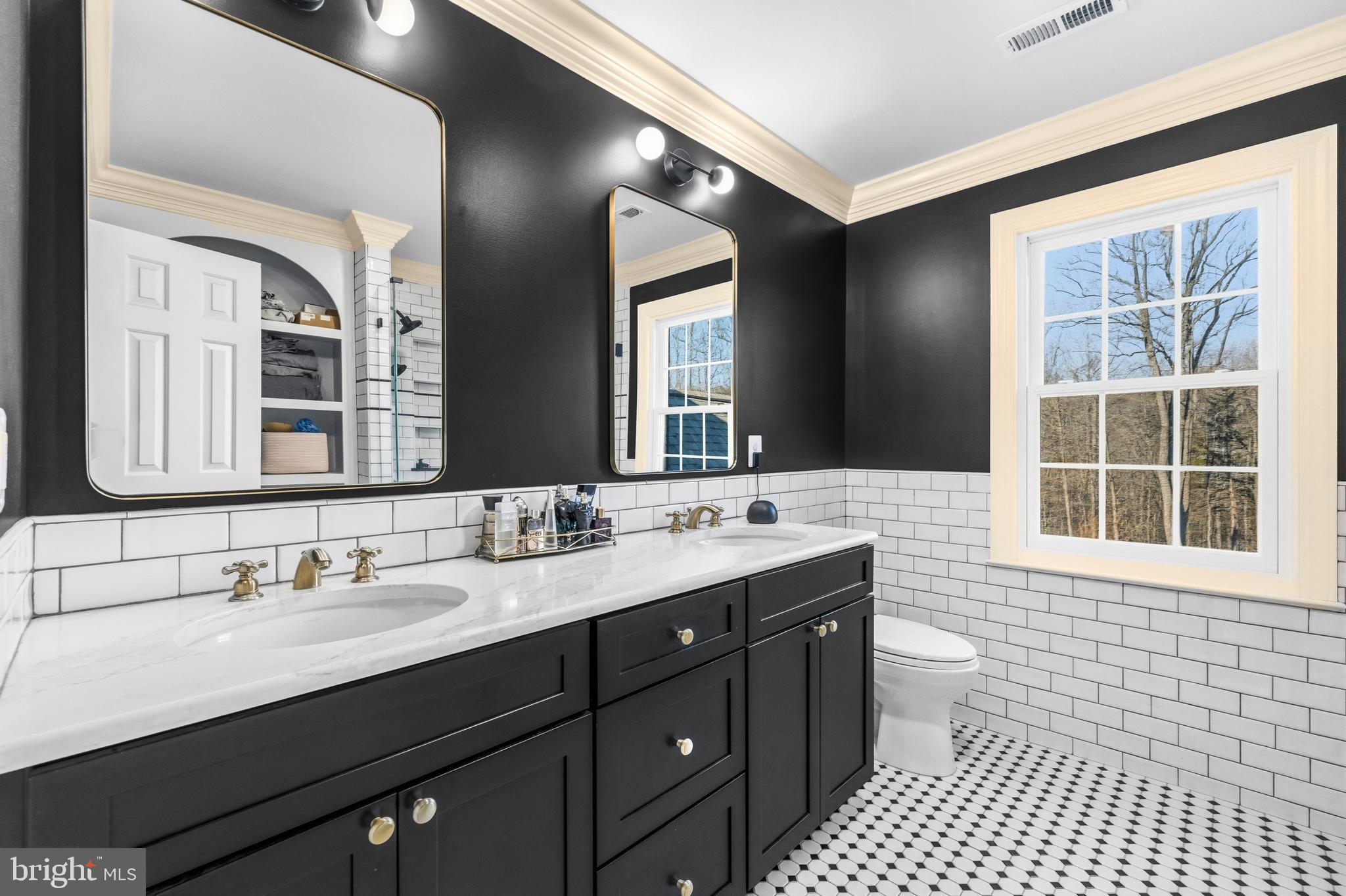 4514 Den Haag Road Warrenton, VA 20187 - Photo 31 of 56 a bathroom with a double vanity sink toilet a mirror and a window