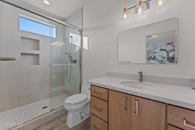 a bathroom with a granite countertop sink a toilet and shower