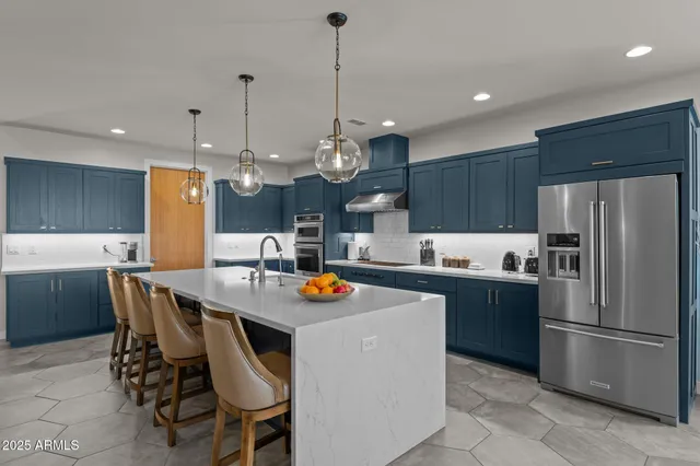 a kitchen with a dining table chairs sink refrigerator and microwave
