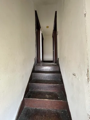 an empty room with wooden floor and entrance