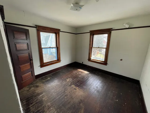 a view of an empty room with closet and a window