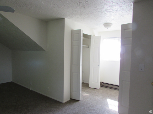 3166 Linden Street Bountiful, UT 84010 - Photo 18 of 25 Unfurnished bedroom featuring light colored carpet, baseboard heating, a textured ceiling, and a closet