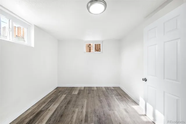 a view of a room with wooden floor and white walls