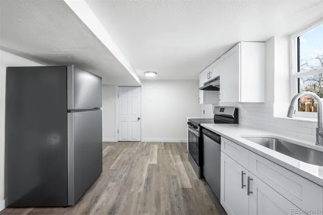 a kitchen with a sink a refrigerator and cabinets