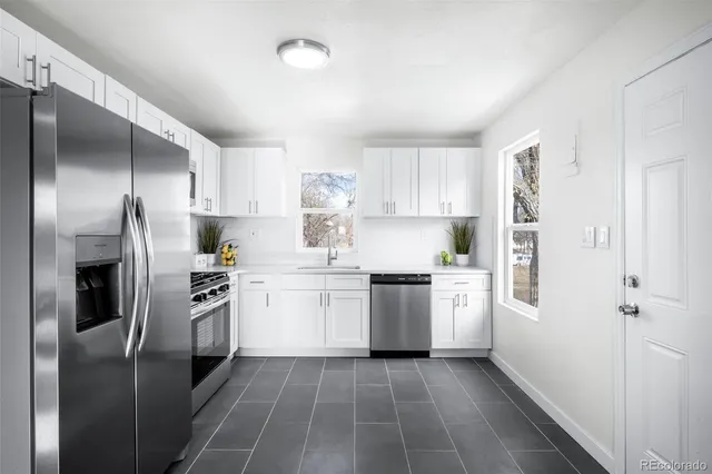 a kitchen with a refrigerator stove top oven and sink