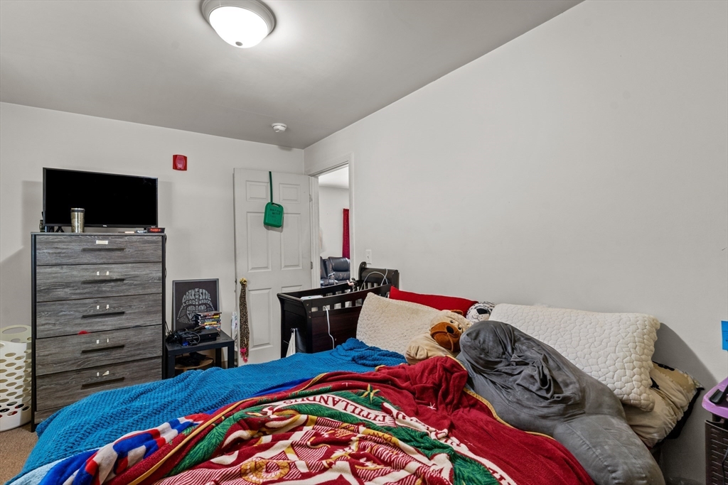 126 Earle Street Woonsocket, RI 02895 - Photo 25 of 42 a bedroom with a bed and a flat tv screen on dresser