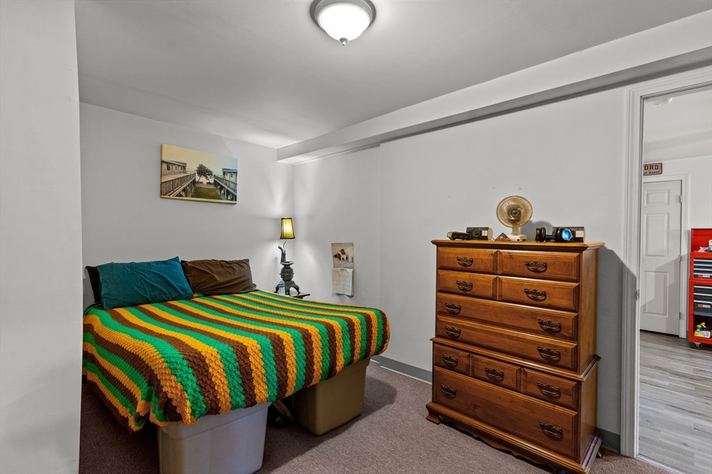 126 Earle Street Woonsocket, RI 02895 - Photo 33 of 42 a bedroom with a bed and a chandelier