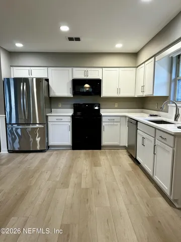 a kitchen with a refrigerator and a sink