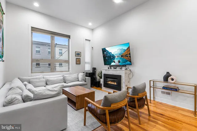 a living room with furniture a flat screen tv and a fireplace