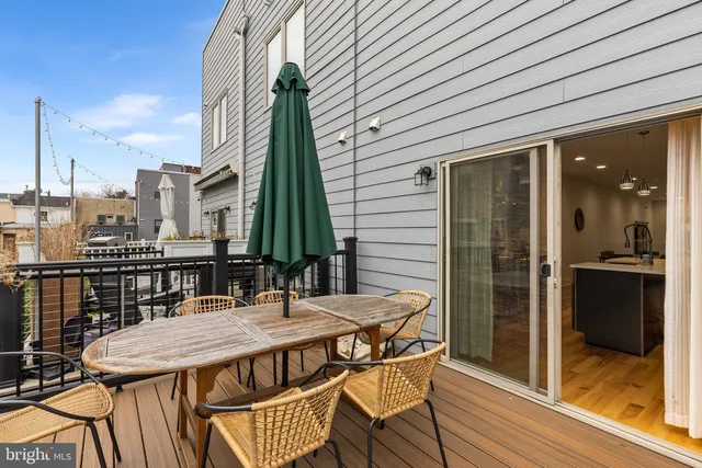 a view of a roof deck with table and chairs and wooden floor