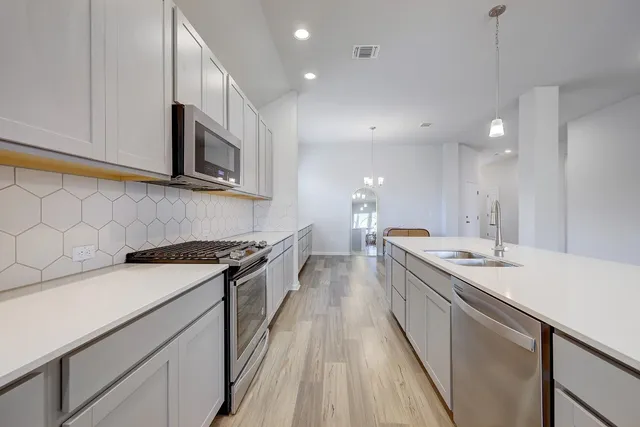 a kitchen with a sink stove and microwave