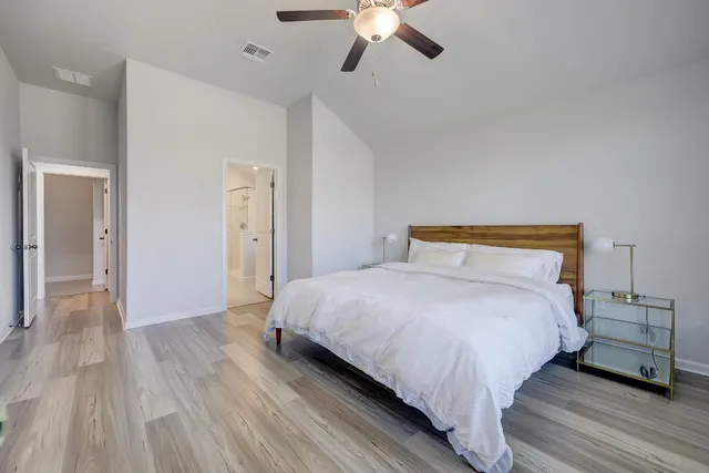 a bedroom with bed and wooden floor