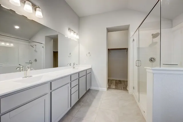 a spacious bathroom with a double vanity sink mirror and shower