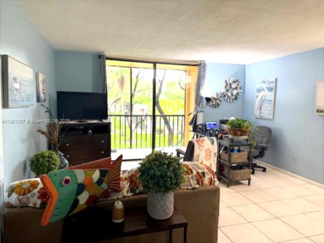 Horizons West Miami, FL 33183 - Photo 4 of 18 a living room with furniture a flat screen tv and a floor to ceiling window