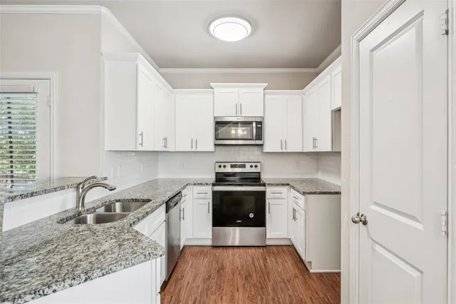 a kitchen with granite countertop a sink stove and refrigerator