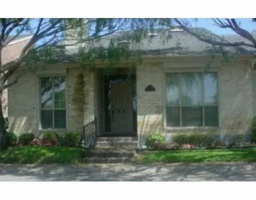 a view of a brick house with a small yard