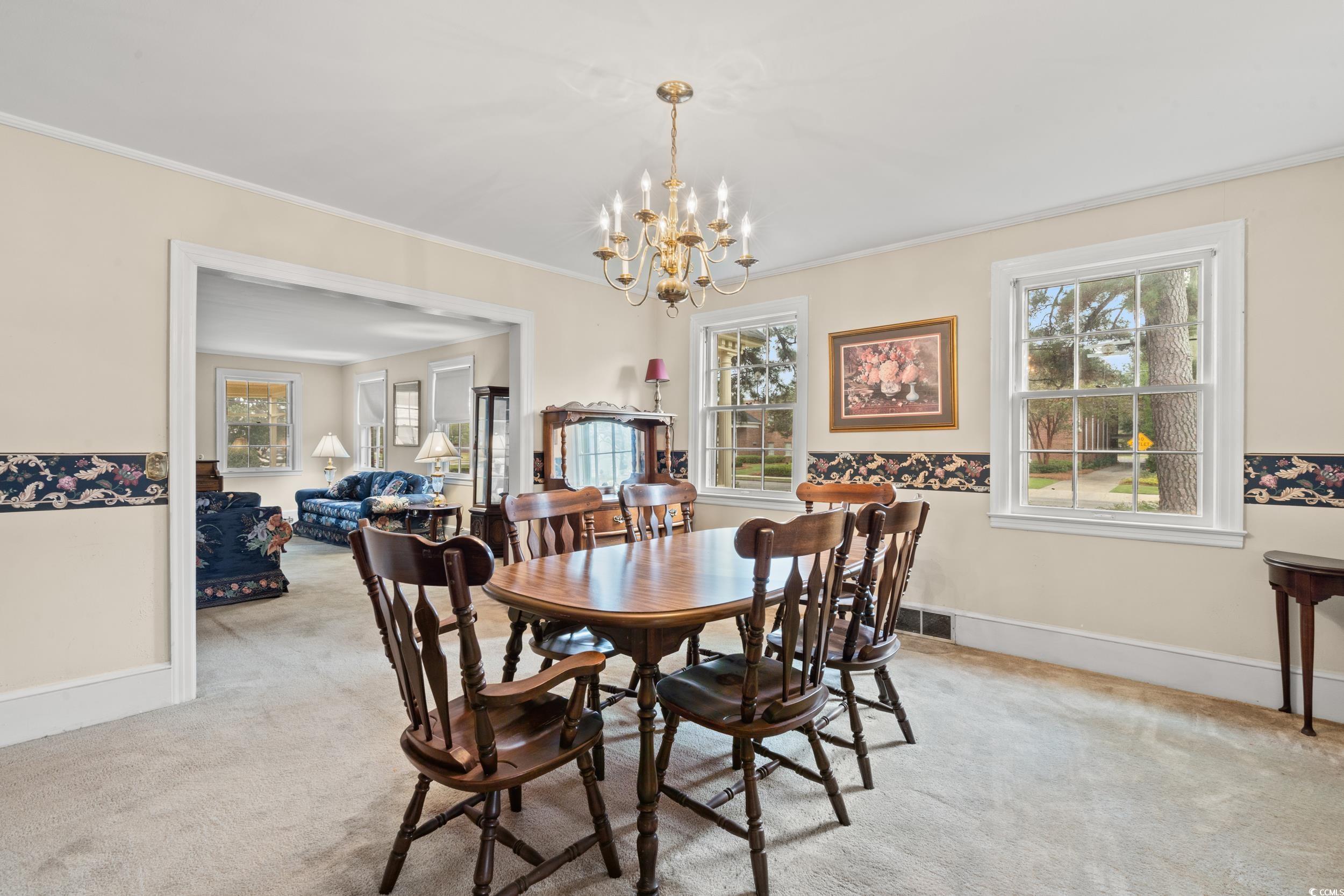 310 North Main Street Mullins, SC 29574 - Photo 30 of 35 Dining room featuring light colored carpet, a chandelier, and ornamental molding