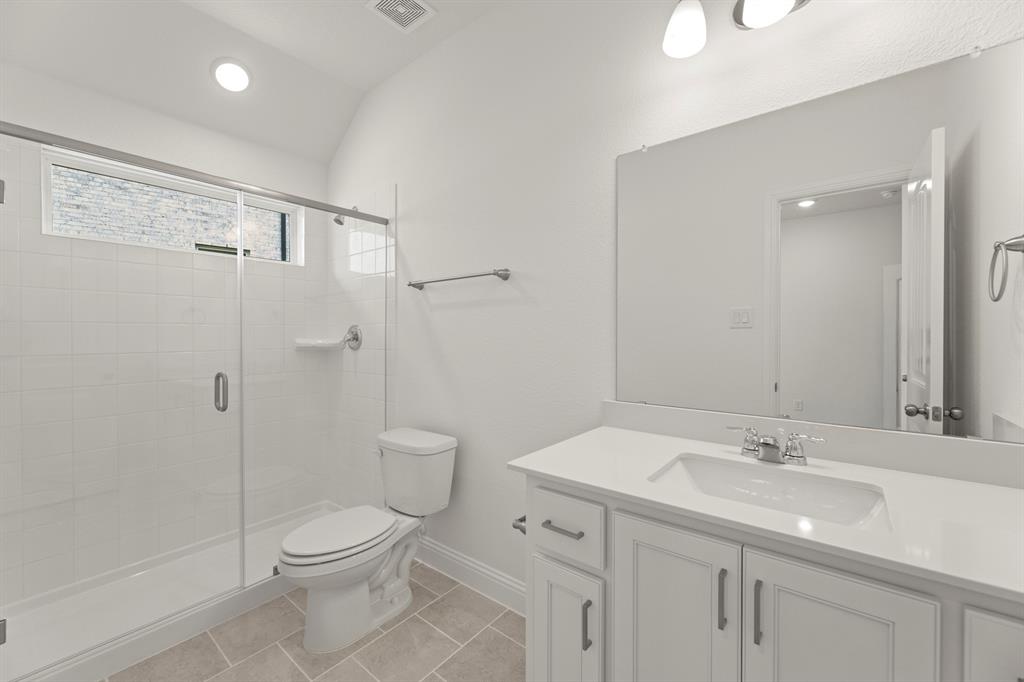 14551 Elion Court Pilot Point, TX 76258 - Photo 17 of 23 a bathroom with a toilet a sink a mirror and a shower