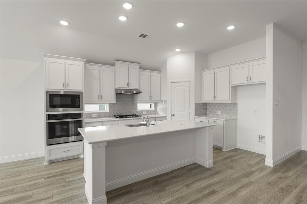 14551 Elion Court Pilot Point, TX 76258 - Photo 4 of 23 a kitchen with a sink stainless steel appliances and white cabinets