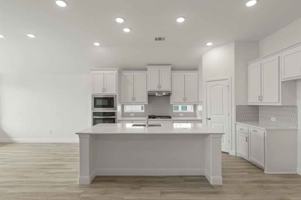 14551 Elion Court Pilot Point, TX 76258 - Photo 6 of 23 a large kitchen with stainless steel appliances granite countertop a stove a sink and a white cabinets