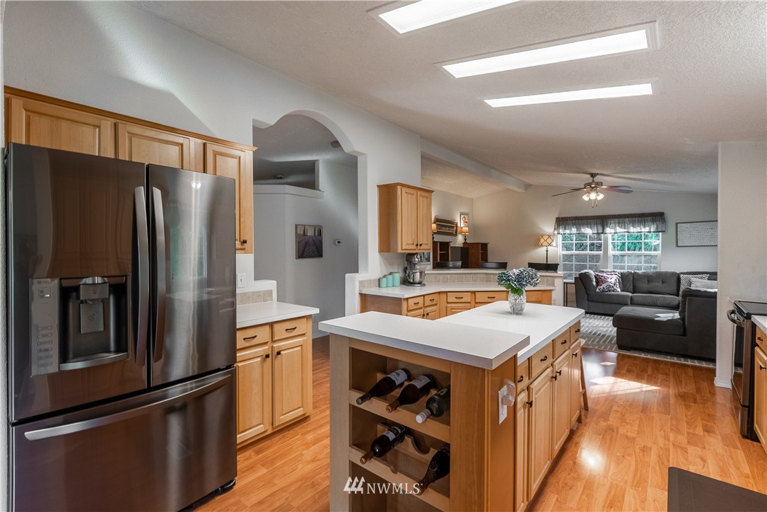 6361 Malloy Road Ferndale, WA 98248 - Photo 14 of 39 a kitchen with stainless steel appliances granite countertop a refrigerator a sink dishwasher a stove and white countertops with wooden floor
