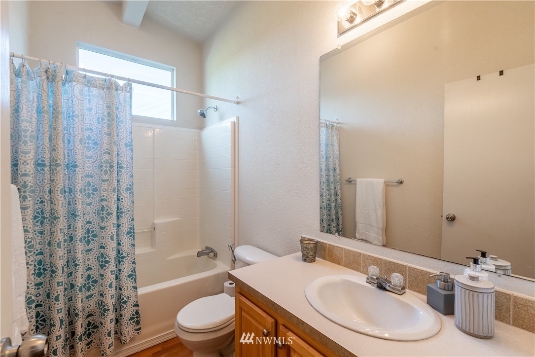 6361 Malloy Road Ferndale, WA 98248 - Photo 22 of 39 a bathroom with a granite countertop sink toilet a mirror and shower