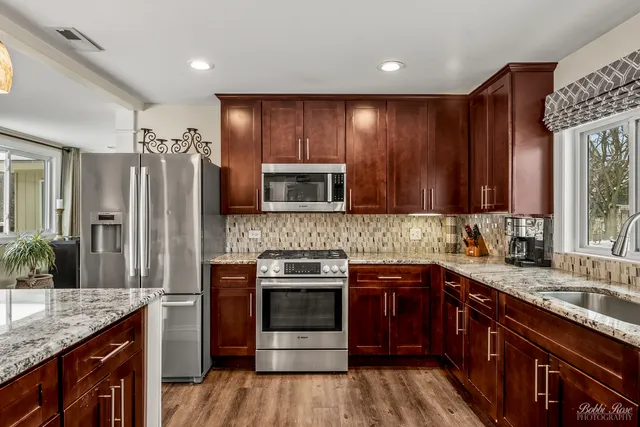 a kitchen with a granite countertop sink and a window