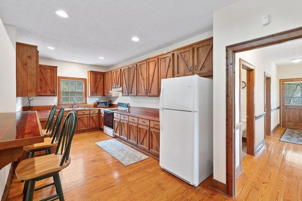 3780 Brownwood Road Madison, GA 30650 - Photo 12 of 25 a kitchen with stainless steel appliances a refrigerator a stove a sink a dining table and chairs