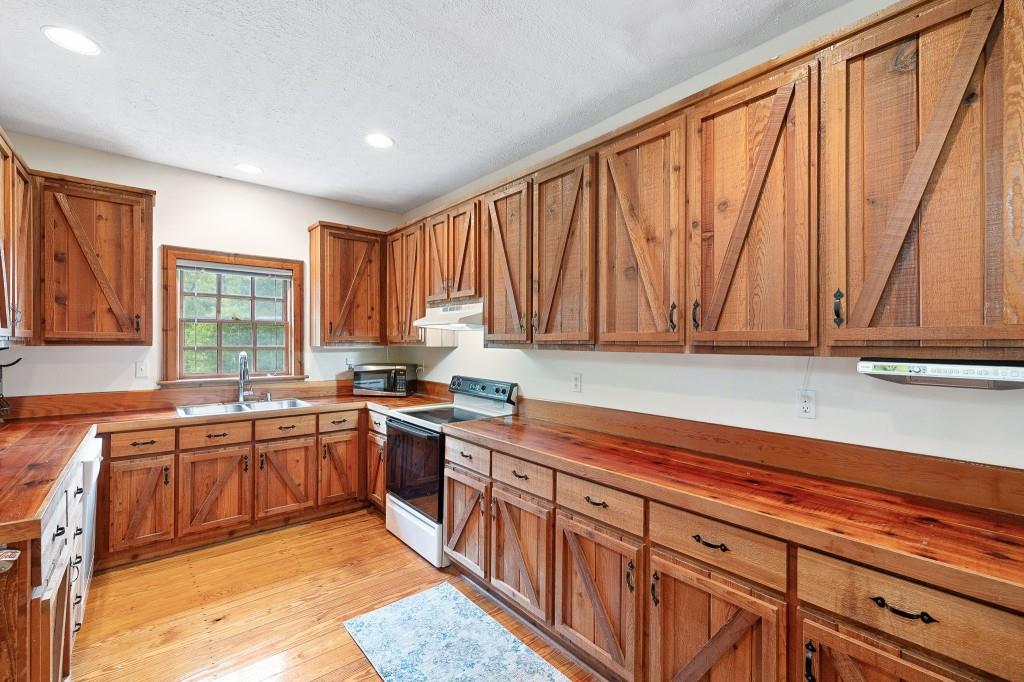 3780 Brownwood Road Madison, GA 30650 - Photo 13 of 25 a kitchen with stainless steel appliances granite countertop white cabinets a sink and dishwasher