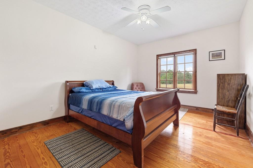 3780 Brownwood Road Madison, GA 30650 - Photo 17 of 25 a bedroom with a bed and wooden floor