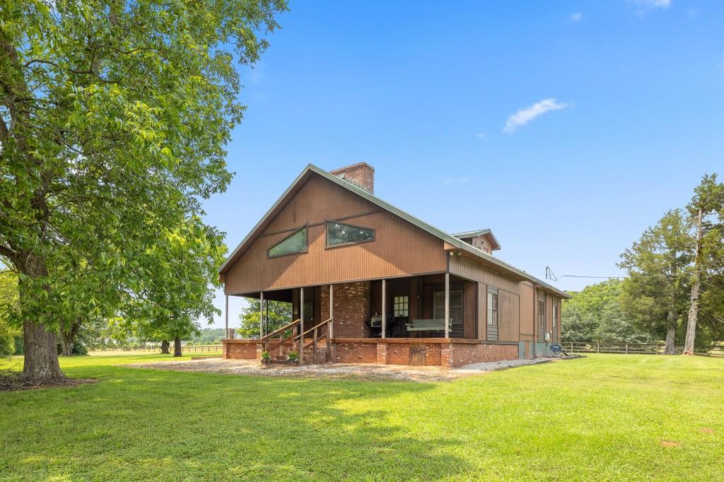 3780 Brownwood Road Madison, GA 30650 - Photo 23 of 25 a front view of a house with a garden and trees