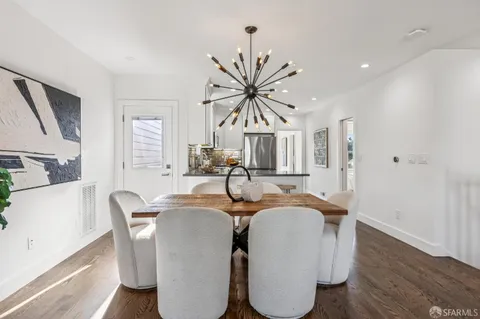 a kitchen with kitchen island granite countertop a refrigerator oven a sink and white cabinets