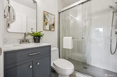 a bathroom with a sink toilet a mirror and shower