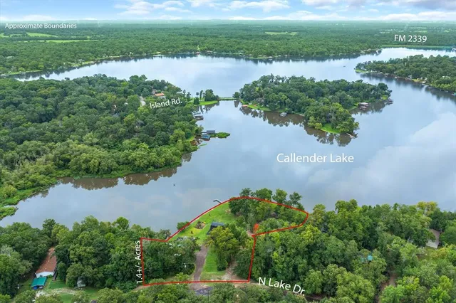an aerial view of lake residential house with outdoor space and trees around